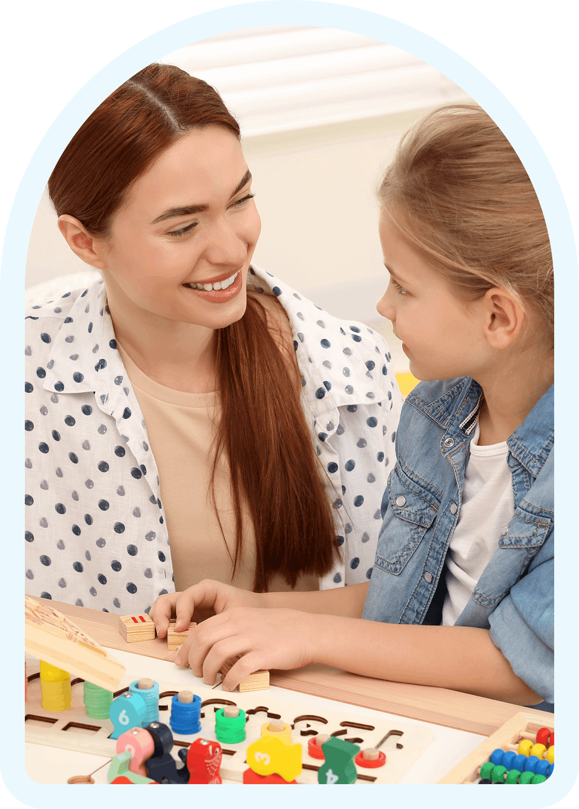 Teacher and child playing with educational toys.