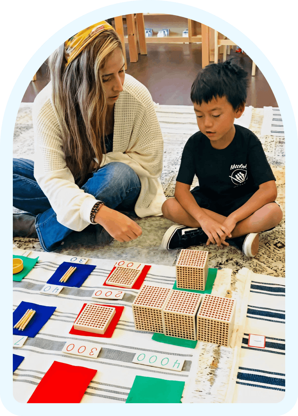 Teacher and child engaging with educational blocks.